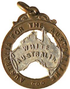 Metal badge with a map of Australia stamped with the words "White Australia", surrounded by a ring reading "Australia for the Australians".