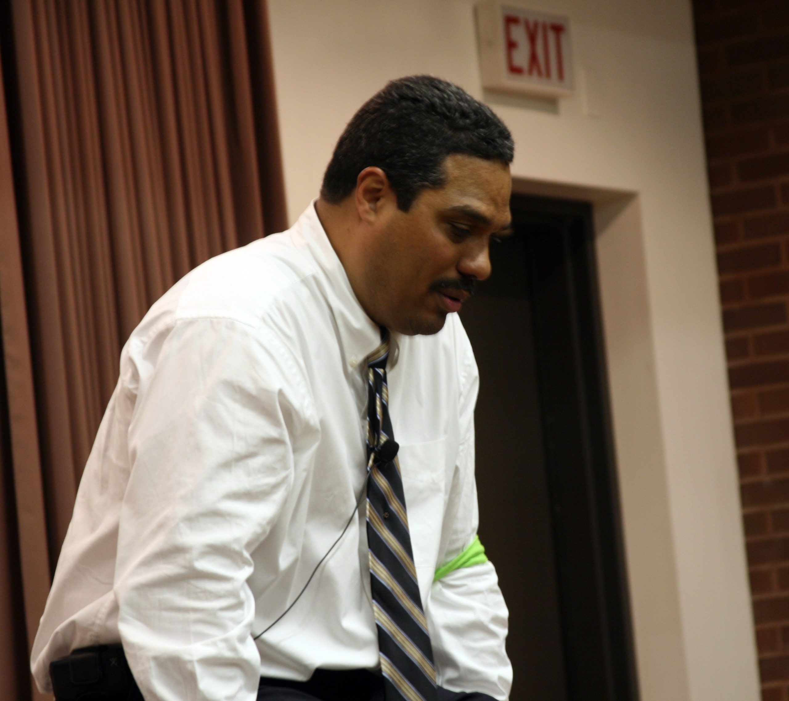 Brown skinned man with a mustache wearing a shirt and tie.